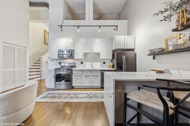 kitchen featuring white cabinetry, sink, a kitchen breakfast bar, and appliances with stainless steel finishes