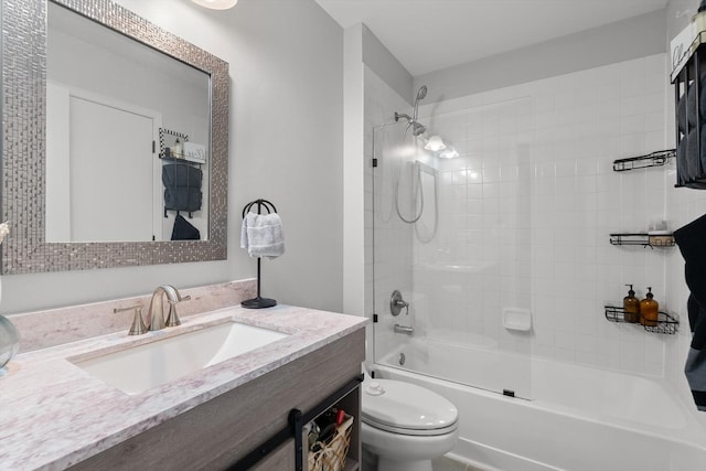 full bathroom featuring tiled shower / bath, vanity, and toilet