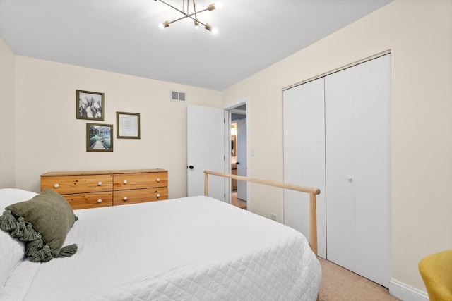 carpeted bedroom featuring a chandelier and a closet