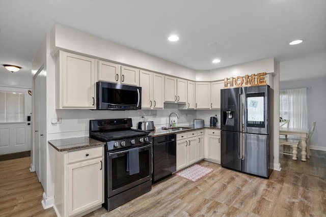 kitchen with white cabinetry, sink, light hardwood / wood-style flooring, and stainless steel appliances