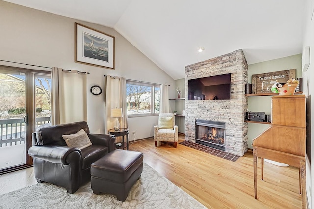 living area featuring wood-type flooring, high vaulted ceiling, and a fireplace