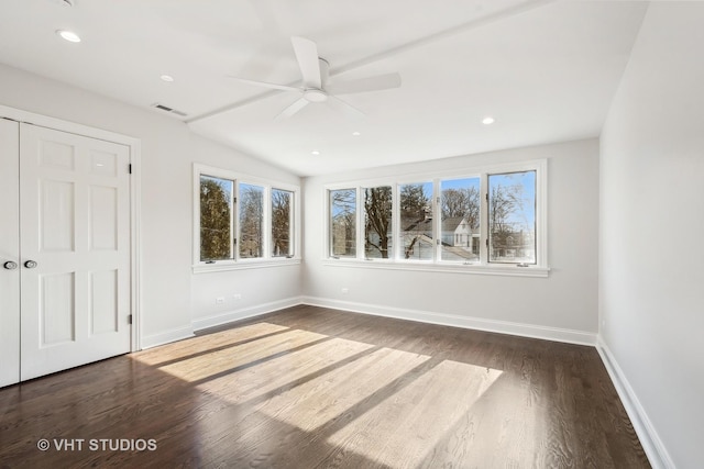 unfurnished room with dark hardwood / wood-style floors, a wealth of natural light, and ceiling fan