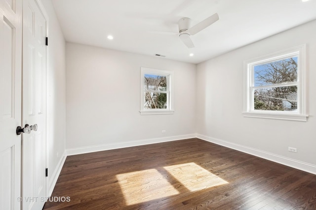 unfurnished bedroom featuring multiple windows, dark hardwood / wood-style flooring, a closet, and ceiling fan