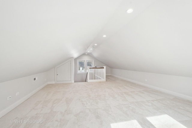 additional living space featuring lofted ceiling and light colored carpet