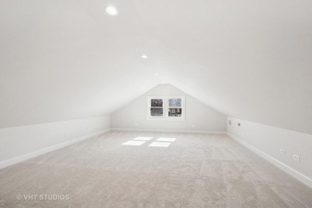 additional living space with vaulted ceiling and light carpet