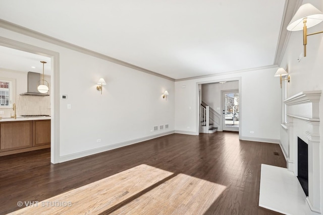 unfurnished living room featuring crown molding, dark hardwood / wood-style floors, and sink