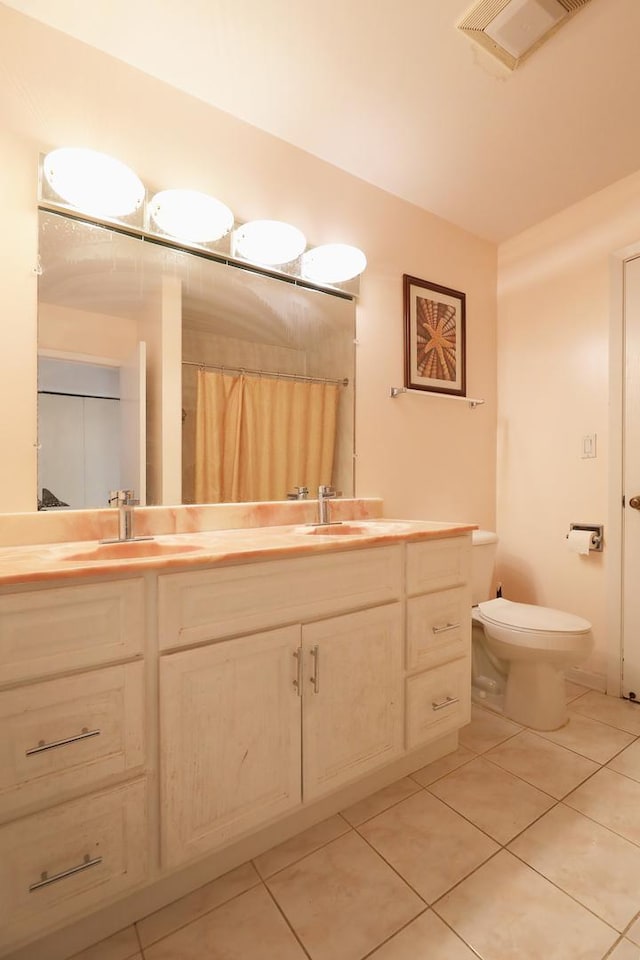 bathroom with tile patterned flooring, vanity, curtained shower, and toilet