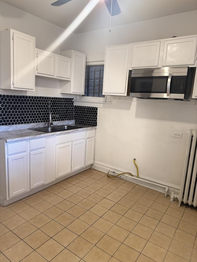 kitchen featuring white cabinetry, ceiling fan, sink, and decorative backsplash