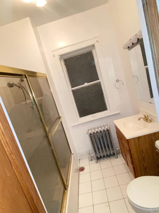 bathroom featuring radiator heating unit, toilet, tile patterned flooring, and vanity