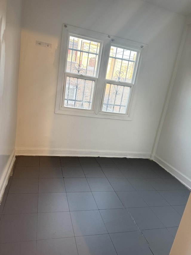 unfurnished room with dark tile patterned floors