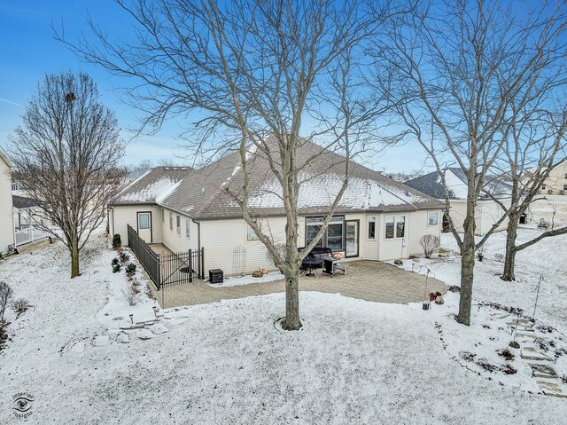 snow covered back of property with central AC unit