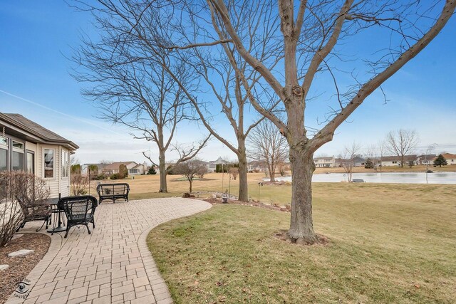 view of yard with a water view and a patio area