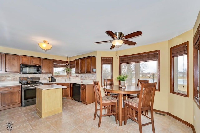 kitchen with decorative backsplash, a center island, light tile patterned floors, ceiling fan, and black appliances