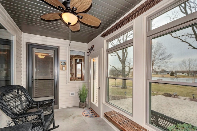 sunroom / solarium featuring a water view and wooden ceiling