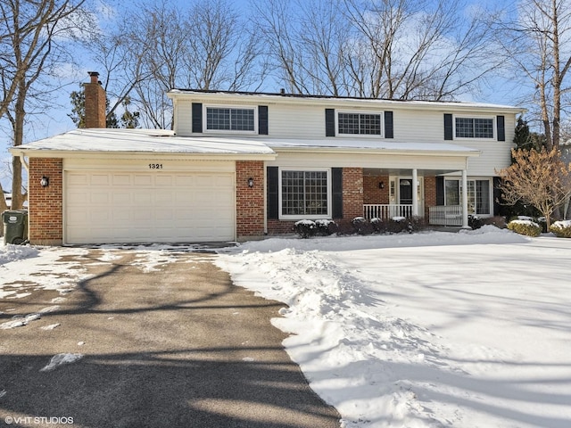 traditional-style house featuring covered porch, driveway, brick siding, and a garage