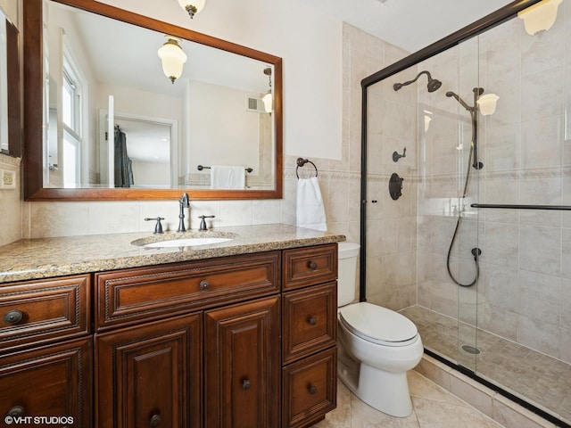 full bathroom with tile patterned flooring, toilet, vanity, tile walls, and a stall shower