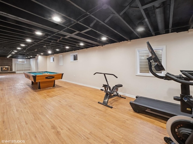 interior space featuring billiards, a brick fireplace, wood finished floors, and baseboards