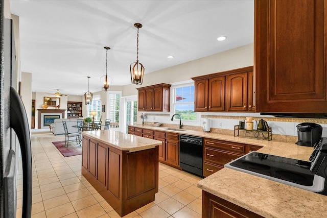 kitchen featuring black appliances, a sink, a kitchen island, a glass covered fireplace, and light tile patterned floors