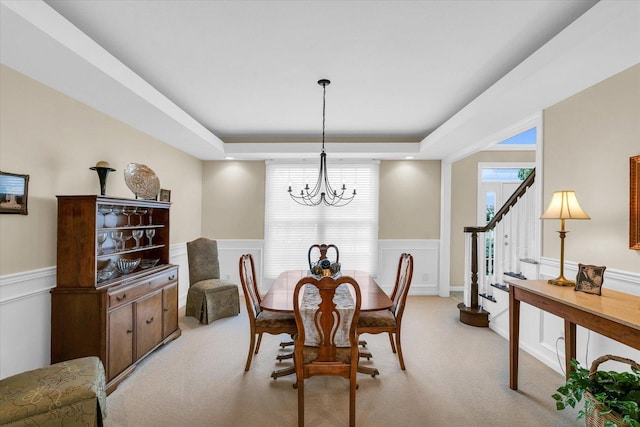 dining area featuring light carpet and wainscoting