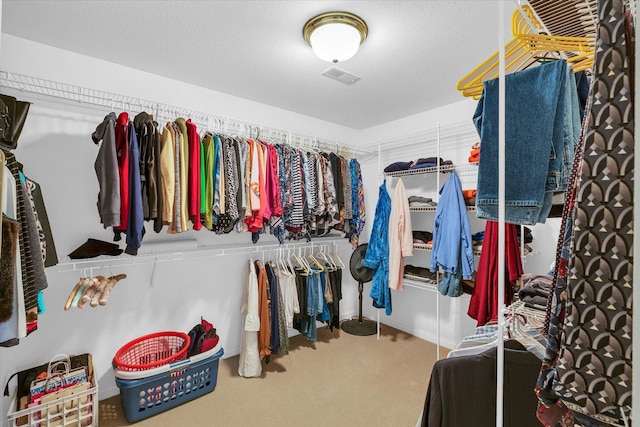 walk in closet with visible vents and carpet