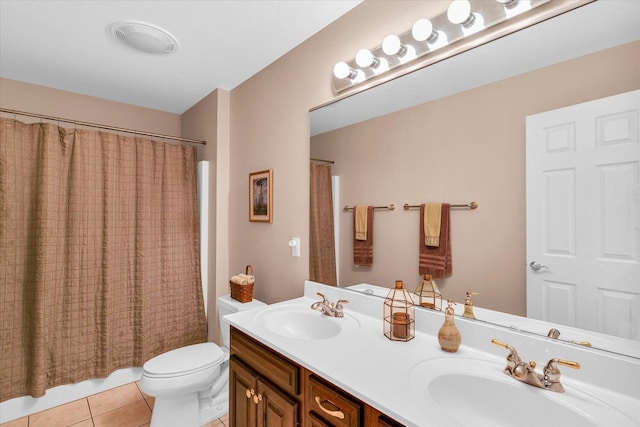 full bathroom with a sink, toilet, double vanity, and tile patterned flooring