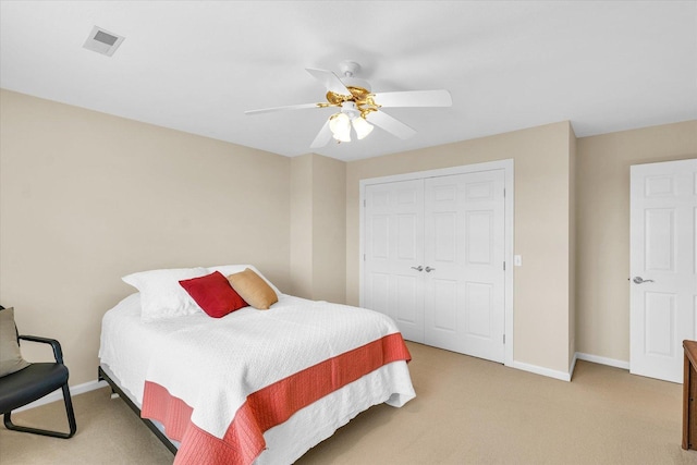 bedroom featuring visible vents, baseboards, light colored carpet, and a closet