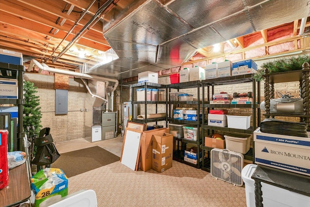 unfinished basement with electric panel, heating unit, and gas water heater