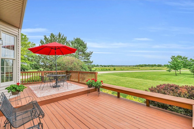 wooden deck featuring a lawn and outdoor dining space