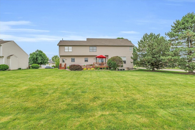 back of property with a yard and a wooden deck