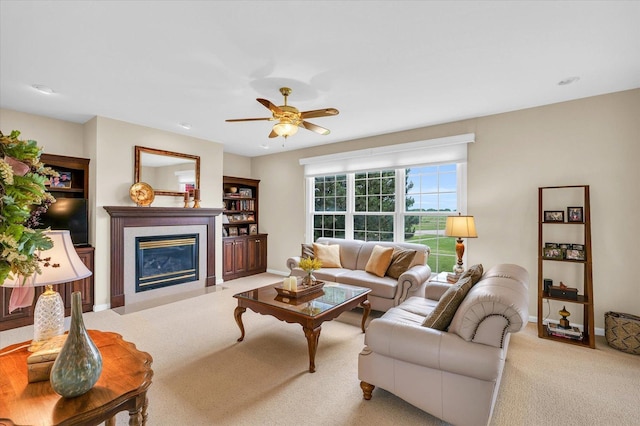 carpeted living room featuring a fireplace, a ceiling fan, and baseboards