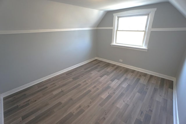 bonus room featuring dark wood-type flooring and vaulted ceiling