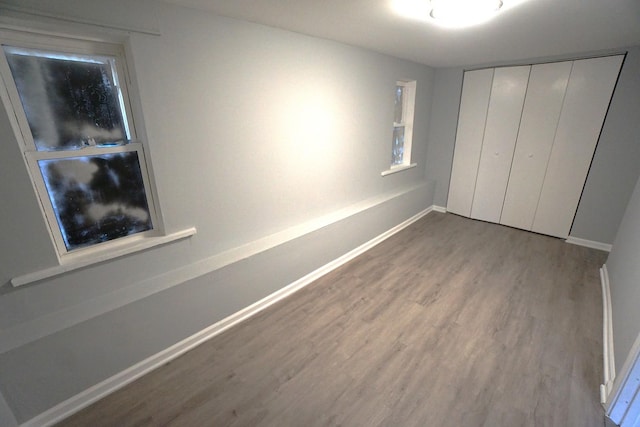 unfurnished bedroom with wood-type flooring and a closet