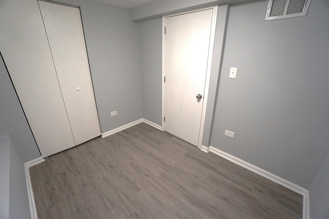 unfurnished bedroom with a closet and light wood-type flooring