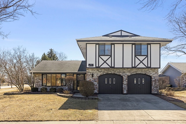 tudor-style house with roof with shingles, brick siding, stucco siding, concrete driveway, and a garage