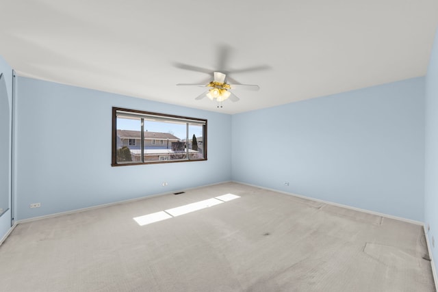 unfurnished room with a ceiling fan, light carpet, and baseboards