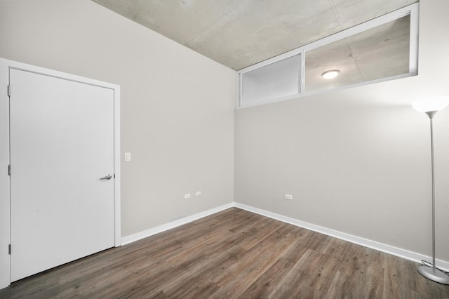 unfurnished room with dark wood-type flooring