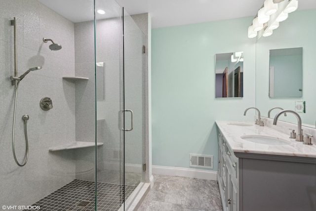 bathroom with vanity and a shower with door