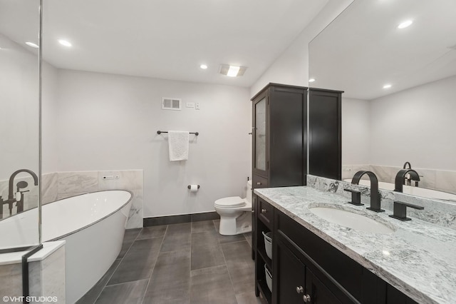 bathroom featuring vanity, tile patterned floors, toilet, and a bathing tub