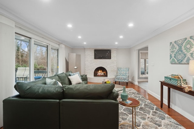 living room with crown molding, a fireplace, and hardwood / wood-style flooring