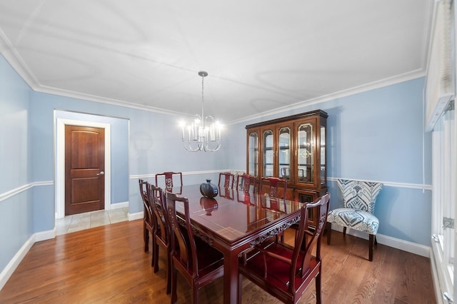 dining area featuring hardwood / wood-style flooring, crown molding, and an inviting chandelier