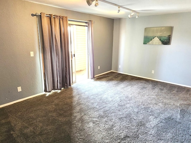 carpeted spare room featuring rail lighting