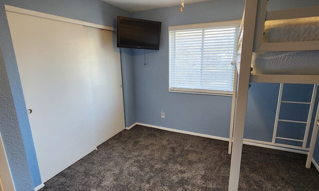 unfurnished bedroom featuring dark carpet