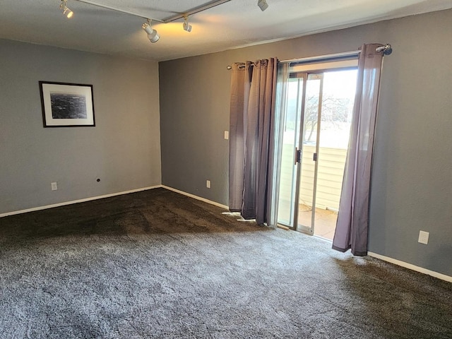 carpeted spare room featuring track lighting