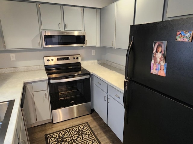 kitchen with sink, dark wood-type flooring, and appliances with stainless steel finishes