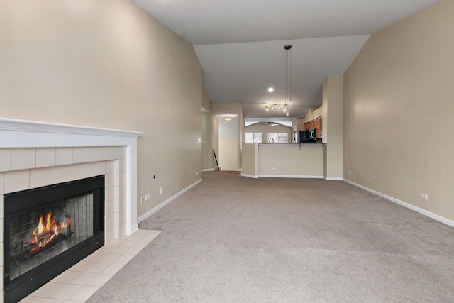 unfurnished living room featuring light carpet, a fireplace, and vaulted ceiling