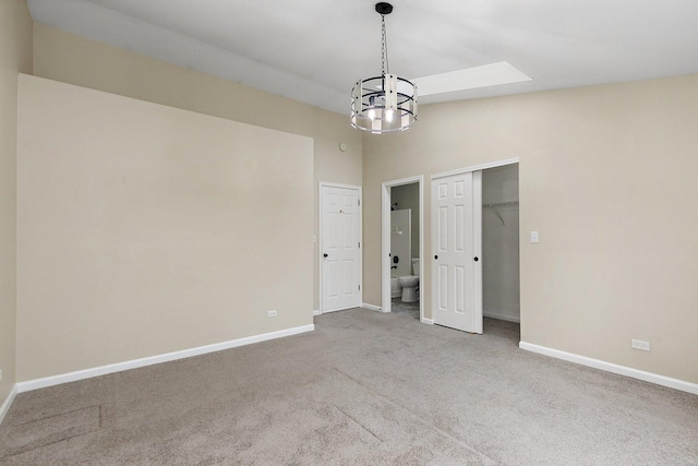 empty room with lofted ceiling with skylight and carpet