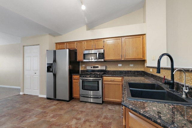 kitchen featuring tasteful backsplash, lofted ceiling, stainless steel appliances, and sink