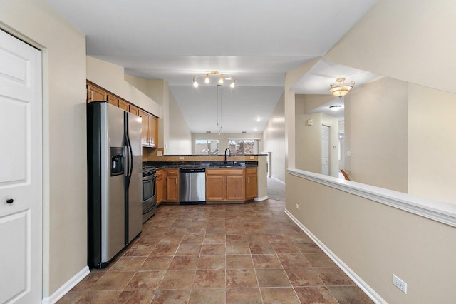 kitchen with sink, vaulted ceiling, kitchen peninsula, and appliances with stainless steel finishes