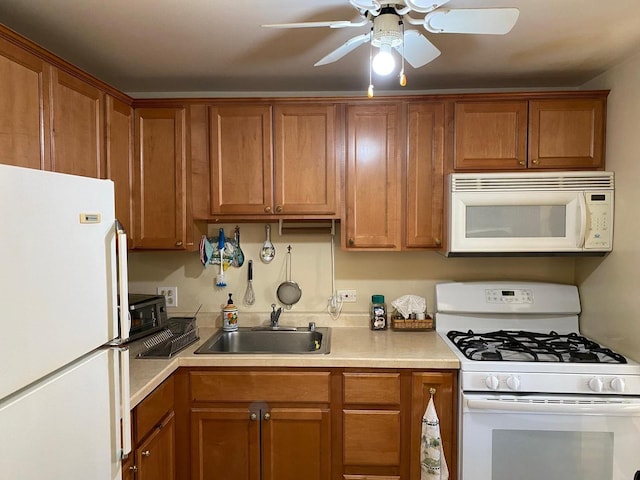 kitchen with brown cabinetry, white appliances, light countertops, and a sink