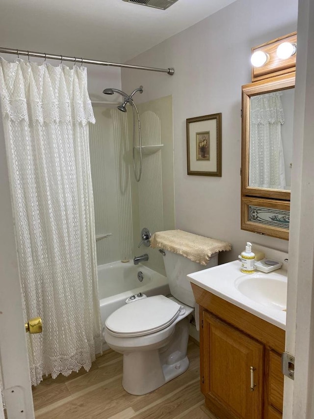 full bath featuring shower / tub combo, visible vents, toilet, wood finished floors, and vanity